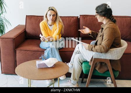 Psychological counseling scene. A psychologist conducts a session with a depressed patient. Stock Photo