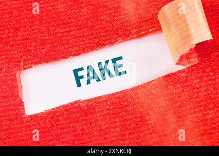 Business concept Copy space. FAKE on a white background under torn paper Stock Photo