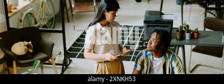 High angle view of gen Z Asian woman and Black man discussing business strategy at work in modern office, website header Stock Photo