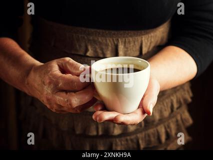 Hands of senior woman holding cup of coffee Stock Photo