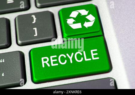Recycle text on green laptop keyboard button. Recycle and conservation concept. Stock Photo