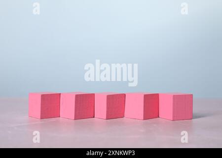 Blank pink cubes on light grey marble table Stock Photo