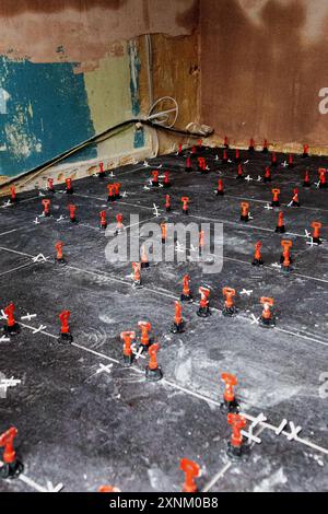 Floor tiles being laid on a kitchen floor in the UK Summer 2024 Stock Photo