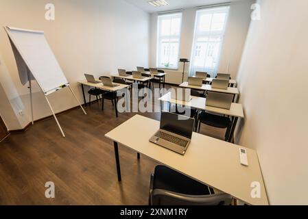 Interior of a modern classroom with desks, chairs and laptops. Empty conference room with laptop on table in office.  Office Business. Conference room Stock Photo