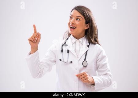 Portrait of doctor who is cheerful and pointing upside. Stock Photo