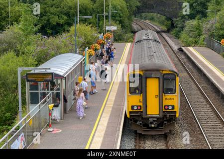 Pontyclun, Wales, UK. - 31 July 2024:  people getting on a Class 150 Sprinter diesel commuter train at the railway station in the village of Pontyclun Stock Photo