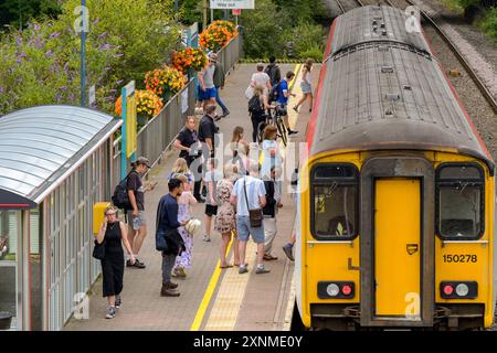 Pontyclun, Wales, UK. - 31 July 2024:  people getting on a Class 150 Sprinter diesel commuter train at the railway station in the village of Pontyclun Stock Photo