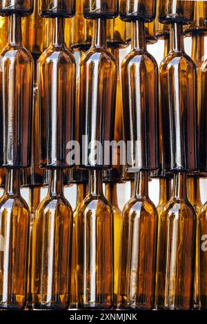 Rows of Empty Glass Bottles in Warm Amber Tones, abstract background Stock Photo