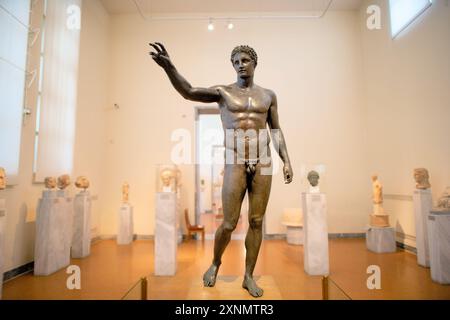 ATHENS, Greece — The Antikythera Ephebe, also known as the Antikythera Youth, is a prominent bronze sculpture displayed at the National Archaeological Museum in Athens. Recovered from the Antikythera shipwreck, this statue dates back to the late 4th century BC and represents an idealized young male figure, showcasing the artistic and cultural significance of the Hellenistic period. The Antikythera Ephebe is noted for its realistic portrayal and intricate craftsmanship, highlighting the excellence of ancient Greek sculptors. Stock Photo