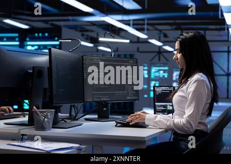 Engineer in data center running system diagnostic tests and error checking utilities to identify and resolve problems. Worker looking for network issues affecting server performance and connectivity Stock Photo