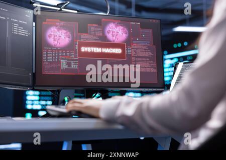 IT professional in server hub trying to protect hardware from hacker stealing information. Worker in high tech data center workplace trying to fix security breach alert caused by virus Stock Photo