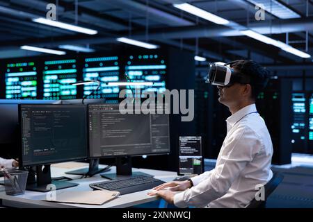 IT specialist using VR headset to do maintenance on server rows in computer network security data center. Engineer using virtual reality to do checkup on mainframes providing processing resources Stock Photo