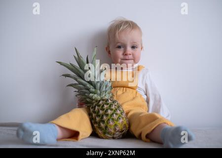 A cute child hold pineapple at home Stock Photo