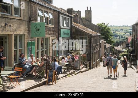 People sitting outside a café in Howarth Main Street, Yorkshire, England, UK Stock Photo