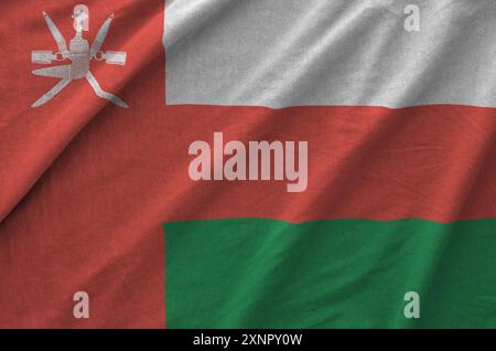 Oman flag depicted on folded wavy fabric of old cloth close up Stock Photo