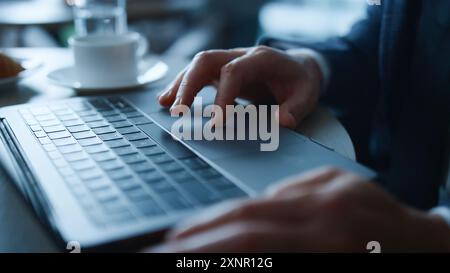 Man's hands typing on laptop keyboard .Businessman surfing net on laptop at loft office .Businessman working on laptop, studying remotely using Stock Photo