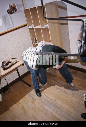 Intense scene of high school students engaging in a physical fight within a classroom. Depicts the chaos and violence that can occur in educational en Stock Photo