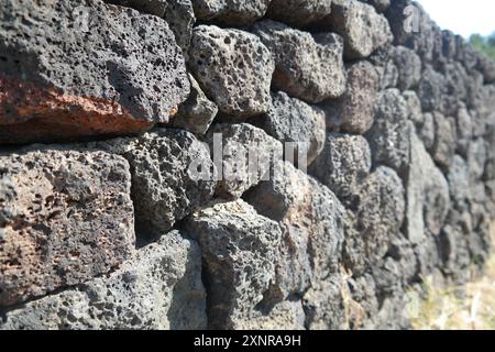 A stone wall background made of basalt stone from Jeju Island, Korea Stock Photo