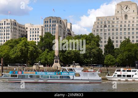 River Thames, London, 27-07-24. Cleopatra's Needle and MI5 building on the bank of the river with a tourist boat taking passengers up the river to vie Stock Photo