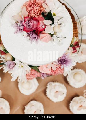 Elegant cake with floral decoration and matching cupcakes, white Stock Photo