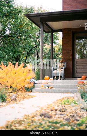 Skeleton decoration on a porch surrounded by pumpkins and autumn Stock Photo