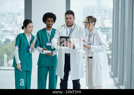 Doctor Using Tablet PC With Colleagues Stock Photo