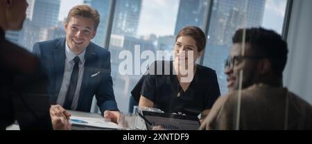 Diverse Colleagues Talking in Big City Office Meeting Room, Discussing Business Strategy. Multiethnic Specialists Brainstorming, Using Laptop Computer, Working On High-Tech Project. Stock Photo