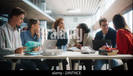 Diverse Group of Students Engaged in a Study Session at a Modern Library. Young Adults Collaborating Over Books and Laptops, Sharing Ideas and Learning Together in a Collegiate Environment. Stock Photo