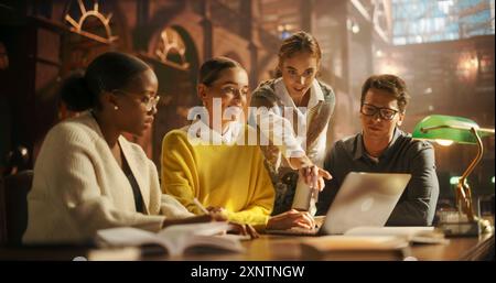 Diverse Group of Students Collaborating on a Project in a Library, Using Laptop for Research. Young Multiethnic Team Engaged in Discussion, Surrounded by Books and Academic Environment. Stock Photo