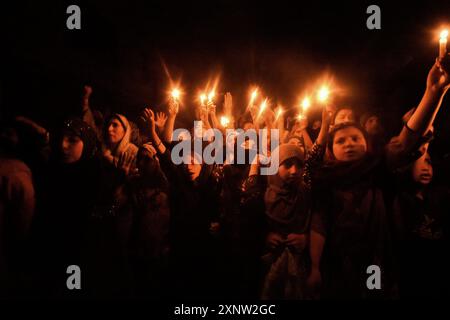 Kashmiri Shia Muslim women and small girls hold candles and shout pro-Palestine and anti-Israel slogans during a candlelight demonstration rally. A candlelight rally was held on the outskirts of Srinagar following the assassination of Ismail Haniya, one of the top political leaders of Hamas, who was killed in Tehran, the capital of Iran. Both Iran and Hamas have blamed Israel for the assassination. Demonstrators expressed solidarity with the affected communities, condemning the violence, and calling for justice and an end to sectarian attacks. (Photo by Mubashir Hassan/Pacific Press) Stock Photo