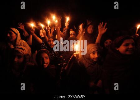 Srinagar, Jammu And Kashmir, India. 1st Aug, 2024. Kashmiri Shia Muslim women and small girls hold candles and shout pro-Palestine and anti-Israel slogans during a candlelight demonstration rally. A candlelight rally was held on the outskirts of Srinagar following the assassination of Ismail Haniya, one of the top political leaders of Hamas, who was killed in Tehran, the capital of Iran. Both Iran and Hamas have blamed Israel for the assassination. Demonstrators expressed solidarity with the affected communities, condemning the violence, and calling for justice and an end to sectarian attacks Stock Photo