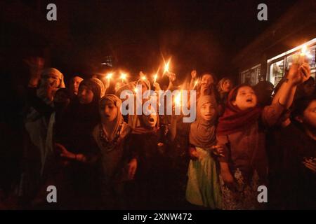 Srinagar, Jammu And Kashmir, India. 1st Aug, 2024. Kashmiri Shia Muslim women and small girls hold candles and shout pro-Palestine and anti-Israel slogans during a candlelight demonstration rally. A candlelight rally was held on the outskirts of Srinagar following the assassination of Ismail Haniya, one of the top political leaders of Hamas, who was killed in Tehran, the capital of Iran. Both Iran and Hamas have blamed Israel for the assassination. Demonstrators expressed solidarity with the affected communities, condemning the violence, and calling for justice and an end to sectarian attacks Stock Photo