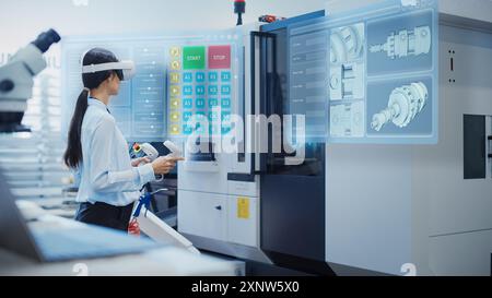 Female Engineer Wearing a Virtual Reality Headset and Operating a Heavy Industry Machine with Controllers at a Factory. Digital Visualization of a Technician Configuring Industrial Machinery with VR Stock Photo