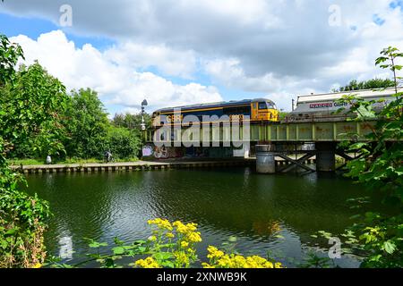 GB Railfreight class 69 heads a northbound freight over the River Nene on the 'Hereward Line' towards Peterborough, Cambridgeshire, England, UK Stock Photo