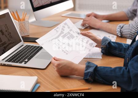 Cartographer working with cadastral map at wooden table, closeup Stock Photo