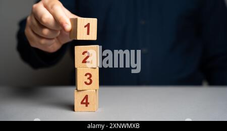 Businessman puts wooden blocks with the number 1 2 3 4. Task list. Alternate items and conditions for implementation. Organization and systematization Stock Photo