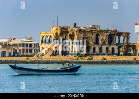 Fishing boat floating in front of the bombed government palace in the the old town of Massawa, Eritrea, Africa Stock Photo