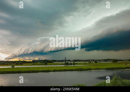 Impressive shelf cloud is moving in over a river in the wide open Dutch landscape Stock Photo