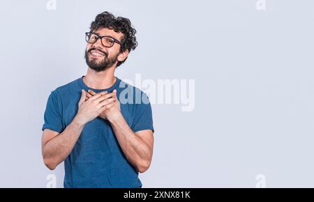 Grateful people smiling with hands on chest. Positive looking friendly handsome man with charming sincere smile feeling thankful, relaxed person with Stock Photo