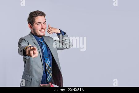 Man making phone gesture with his fingers, Hispanic young man making phone gesture and pointing to the front, a signal of a man calling Stock Photo