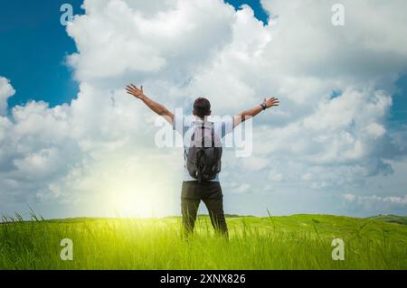 Backpacker man in the field spreading his hands, concept of successful man spreading his hands Stock Photo