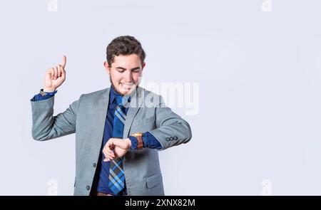 Business man shocked with a new idea, surprised man in suit jacket pointing finger up, business man looking at his watch and pointing up Stock Photo