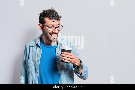 Excited person holding coffee glass on isolated background, Excited young man holding paper coffee cup, Excited man with coffee glass Stock Photo