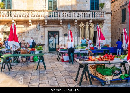 DUBROVNIK, CROATIA - JUNE 29, 2024: People shop at Gunduliceva Poljana open-air market in Dubrovnik Old City Stock Photo