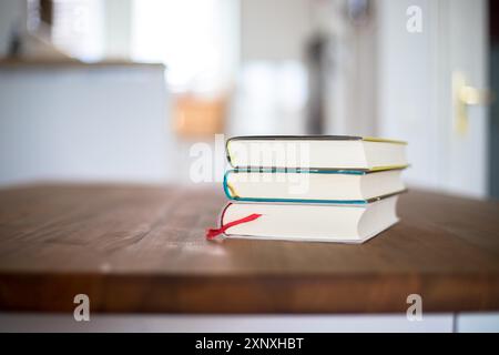 Stack of books lying on wooden desk at home. Knowledge and science Stock Photo