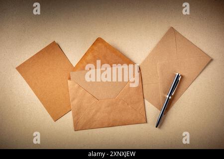 Greeting card mockup in a brown kraft envelope, with a blank card, shot from the top on brown paper Stock Photo