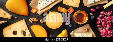 Cheese panorama with wine and fruit, shot from above on a black background Stock Photo