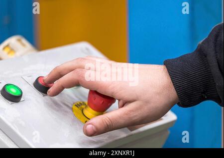 Hand pressing the red emergency button or stop button for industrial machine, Emergency Stop for Safety Stock Photo