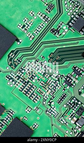 Green printed circuit board (PCB) close-up shot with a lot of electronic components Stock Photo