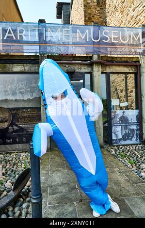 Man in shark costume in front of the Lancaster Maritime Museum Stock Photo